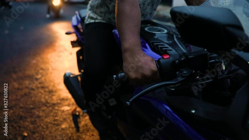 Motorcycle Throttle - Closeup of a male biker's hand revving a motorcycle and lights turning on. photo