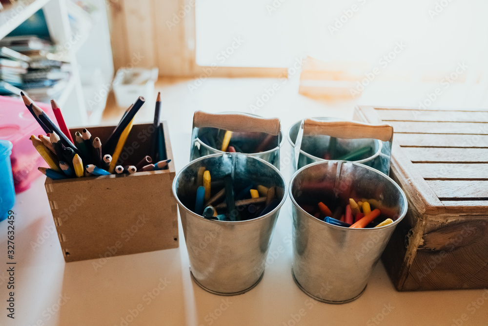 Colored pencils in metal pails in a nursery school