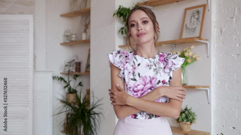 Beautiful girl with brown hair in a blouse posing, smiling in a beautiful interior, slow motion Beautiful girl with brown hair in a blouse posing, smiling in a beautiful interior, slow motion