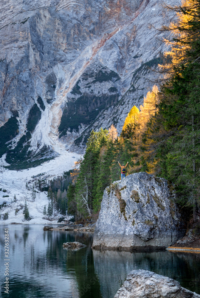 the young man with backpack near famous lake Braies in Italy with Dolomites mountains in background, Pragser wildsee the young man with backpack near famous lake Braies in Italy with Dolomites mountains in background, Pragser wildsee