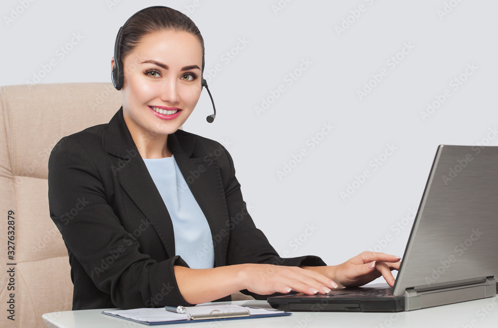 Female phone operator is smiling and and talks on the phone. Helpline answering. Work in the office. Call Center Service. Female phone operator is smiling and and talks on the phone. Helpline answering. Work in the office. Call Center Service.