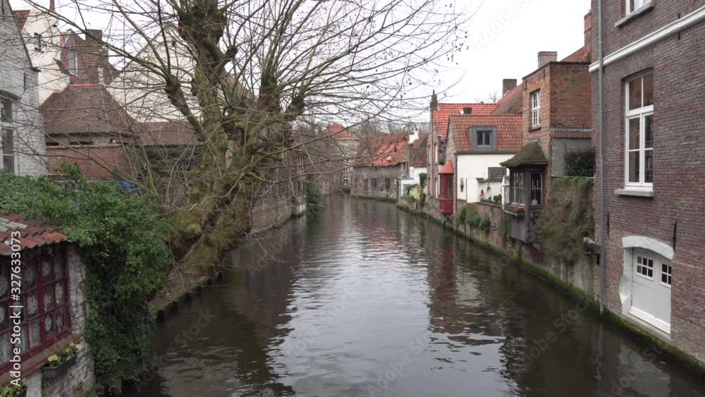 Static wide shot of quiet canal in Bruges, Belgium Static wide shot of quiet canal in Bruges, Belgium