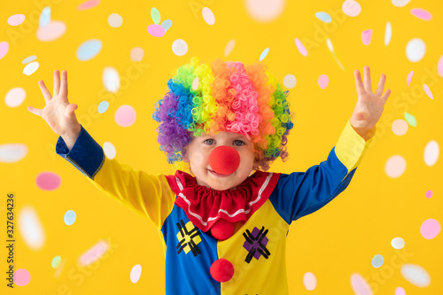Slika na platnu Funny kid clown playing against yellow background