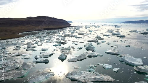 overview of the ice in the fjord, hundreds of icebergs floating around in the calm water. photo