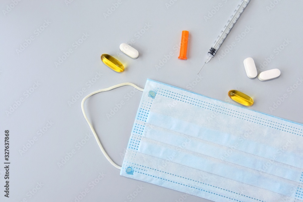 Pills, syringe, thermometer and protection mask on neutral background. Seasonal disease concept. Set for cold and flu treatment. Pills, syringe, thermometer and protection mask on neutral background. Seasonal disease concept. Set for cold and flu treatment.
