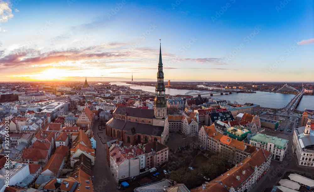 Aerial panoramic view to histirical center Riga, quay of river Daugava. Famous Landmark - st. Peter's Church's tower and City Dome Cathedral church, Old Town Monument. Latvia, Europe. shot from drone