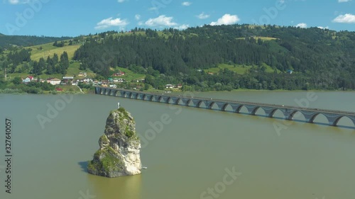 Aerial shot over passing the summit cross located on Piatra Teiului in the carpathian mountains photo