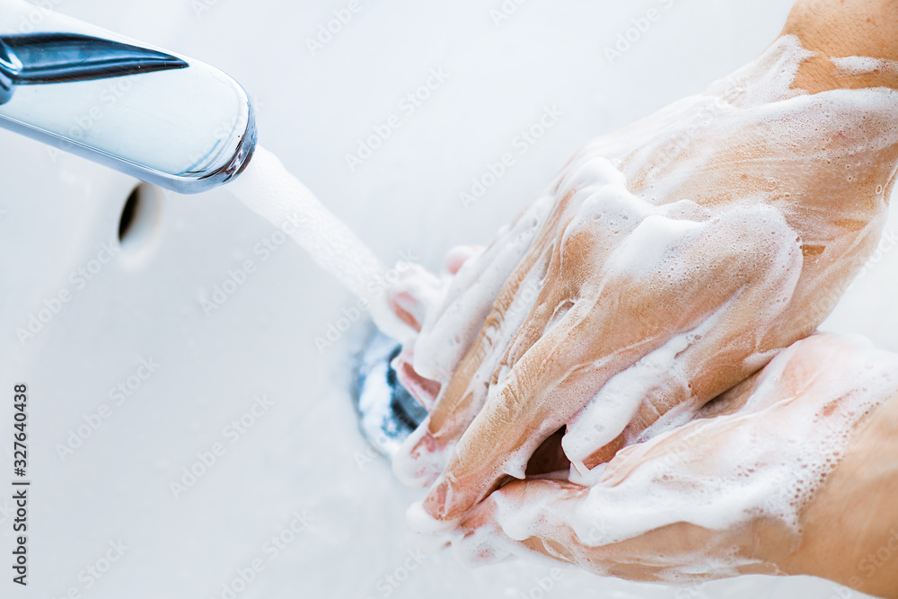 Fototapeta premium Woman use soap and washing hands under the water tap. Hygiene concept hand detail.
