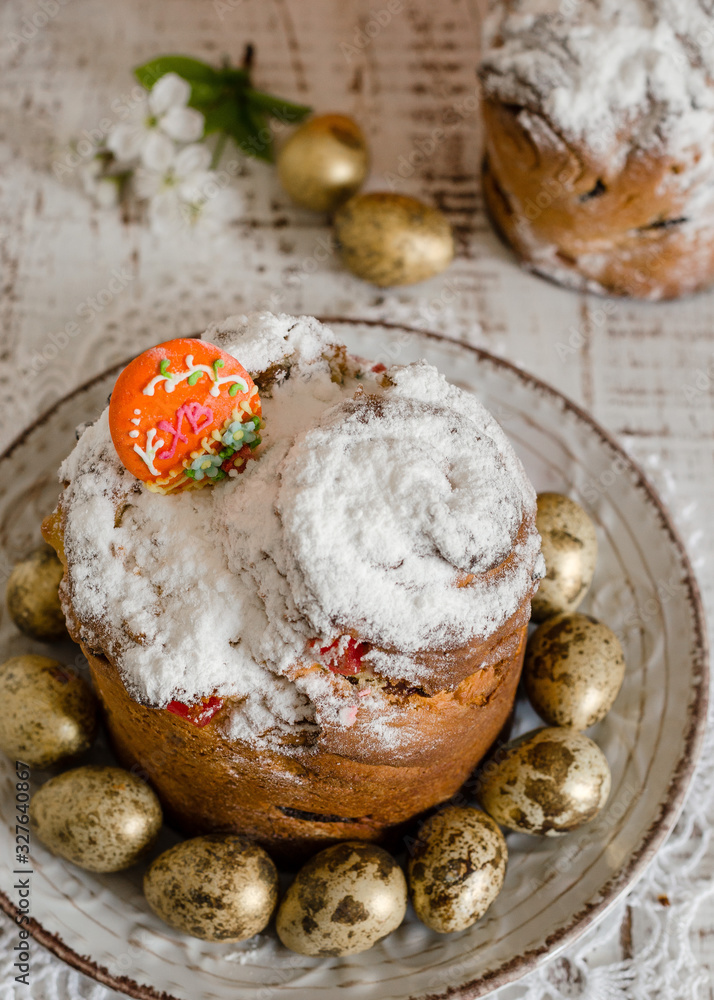 Easter cake, quail colored eggs and a sprig of blooming cherry on the rustic white wooden background. Easter concept