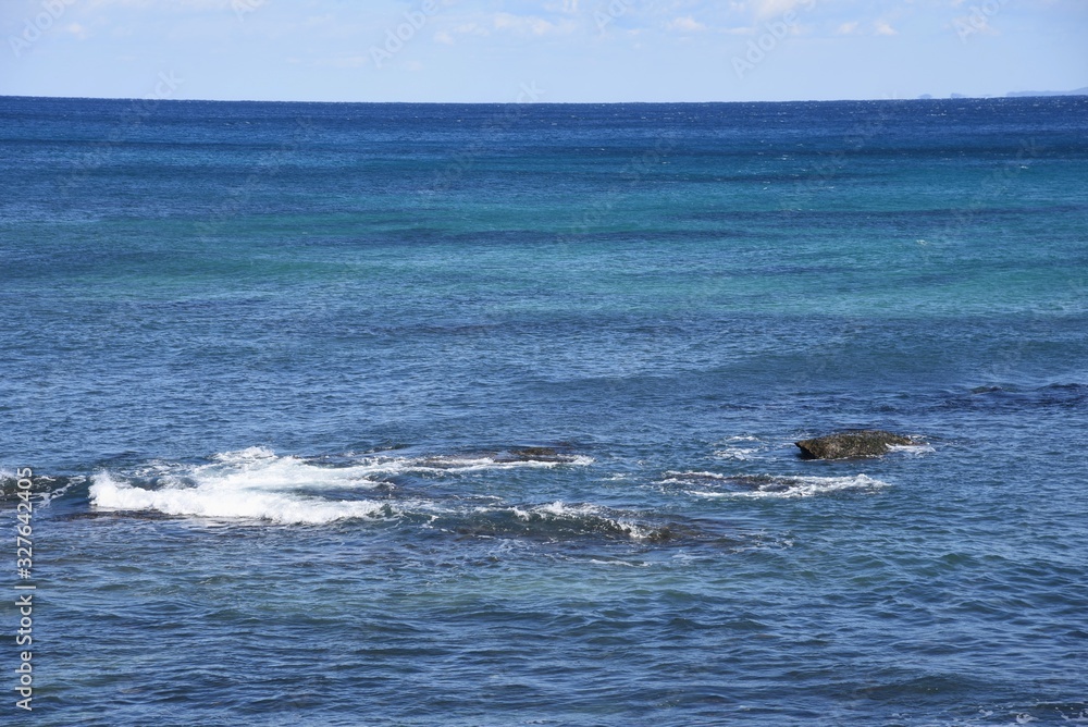 Fototapeta premium Winter Seascape / Blue sea and white waves breaking on rocks.