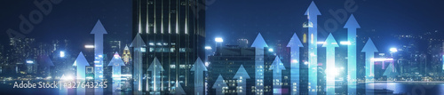 Financial growth concept. Up arrows on modern night city. Panoramic business background.