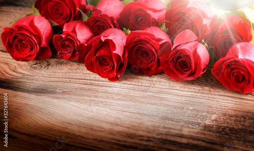 Red roses on vintage old wooden board.  Valentines day web wide rose banner