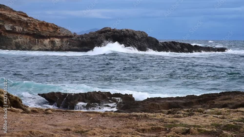 Rough sea by Alghero rocky shore under a cloudy sky Rough sea by Alghero rocky shore under a cloudy sky