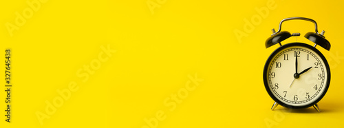 Time background concept. Vintage classic alarm clock on yellow empty background. Time management comcept