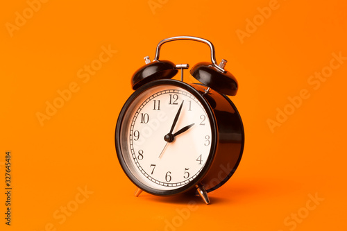 Time background concept. Vintage classic alarm clock on orange empty background. Time management concept