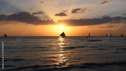 Silhouette Paraw sailing boats under orange sunset at Boracay Island of Philippines 60fps photo
