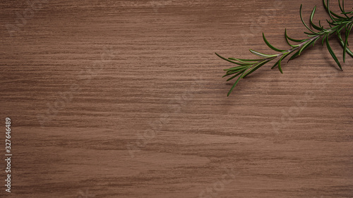 a sprig of rosemary on a brown background. copy space
