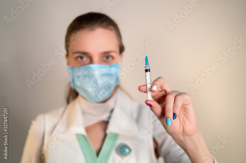 Female doctor wearing protective blue mask  white uniform. Banner epidemic  virus protection. Patients need to get the flu vaccine. Deficiency in medicines and new protective equipment for koronavirus