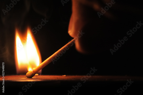 Matchstick ignites with the help of the matchbox with beautiful flames and smoke.