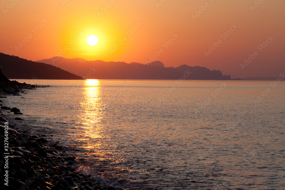 Scenic landscape of calm sea sun against the backdrop of high hills or mountains during summer vacation. The concept of travel to miserable countries. Place for advertising