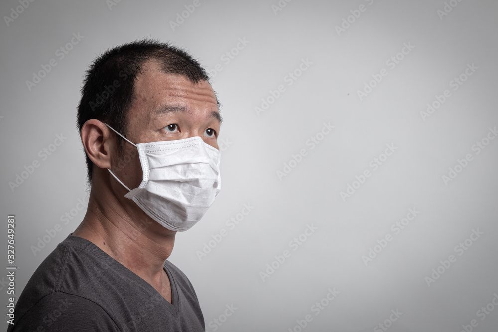 Asian man wearing surgical mask to prevent flu virus and PM2.5 dust air pollution Asian man wearing surgical mask to prevent flu virus and PM2.5 dust air pollution