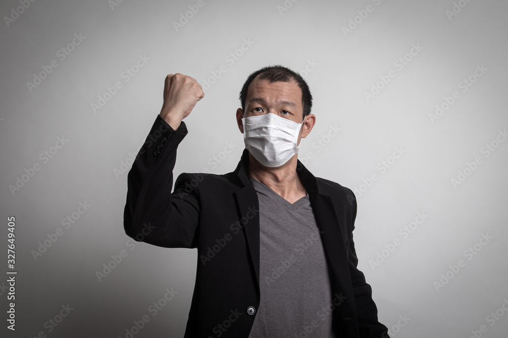 Strong Asian man wearing N95 mask to prevent flu virus and PM2.5 dust air pollution Strong Asian man wearing N95 mask to prevent flu virus and PM2.5 dust air pollution