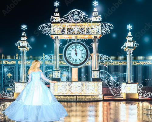 Fototapeta Beautiful princess in blue long dress runs away from the queens ball when the clock is struck 12pm