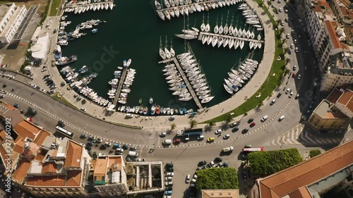 Flight over the harbour of Palermo early sunny morning. Busy traffic on the waterfront. Two kayaks floating among yachts. Sicily, Italy. May 2019. Aerial top-down shot