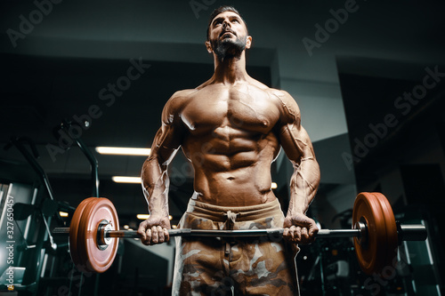 Bodybuilder strong man pumping up biceps muscles © antondotsenko