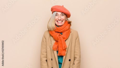 senior or middle age pretty woman looking happy and goofy with a broad, fun, loony smile and eyes wide open