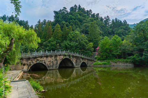 Old stone bridge to cross a green lake. Near Purple Cloud Palace in Wudang Shan Mountains, Hubei province, China