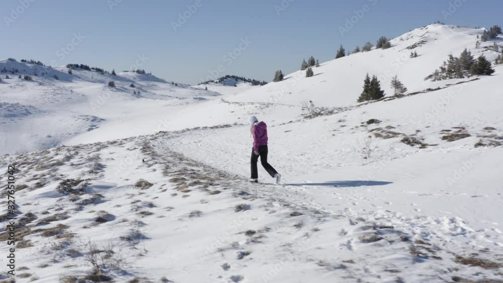 Trekking with drone young woman walking in mountains alone - Beautiful landscape covered with snow and untouched nature. Young caucasian model smiling and enjoying sunshine in morning - 4k Trekking with drone young woman walking in mountains alone - Beautiful landscape covered with snow and untouched nature. Young caucasian model smiling and enjoying sunshine in morning - 4k