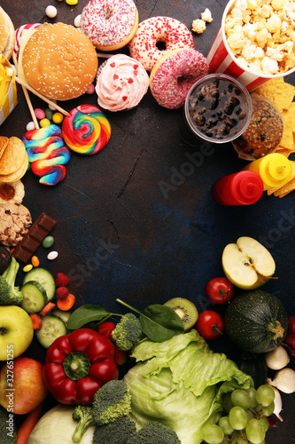 Fototapeta Naklejka Na Ścianę i Meble -  healthy or unhealthy food. Concept photo of healthy and unhealthy food. Fruits and vegetables vs donuts,sweets and burgers