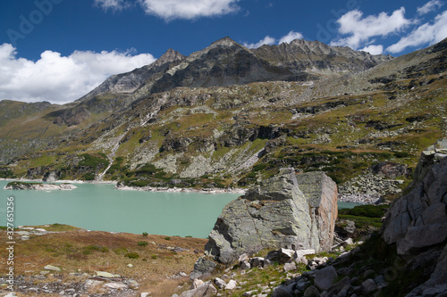 Large stones at the Alpine lake with turquoise water