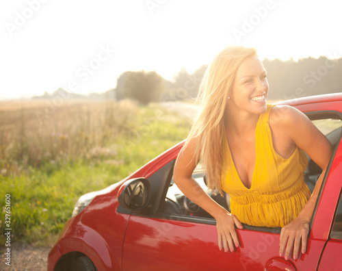 Young woman in a red car