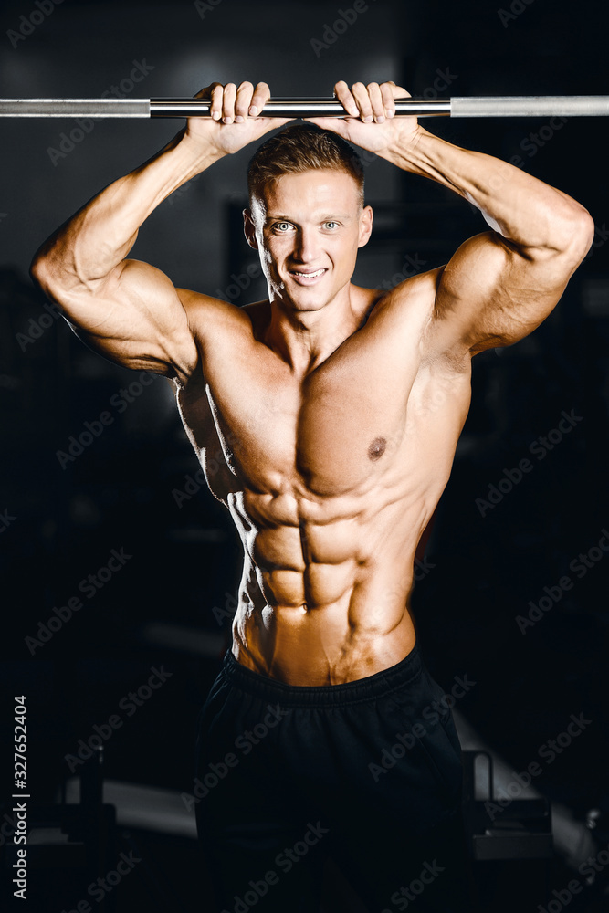 Bodybuilder strong man pumping up abs muscles Bodybuilder strong man pumping up abs muscles