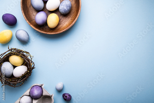 Naturally colorful dyed Easter eggs on blue background. Happy Easter holiday theme, banner