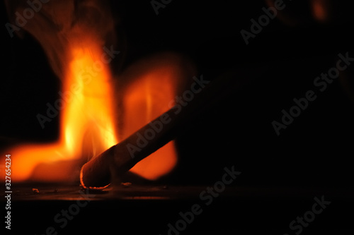 Matchstick ignites with the help of the matchbox with beautiful flames and smoke.