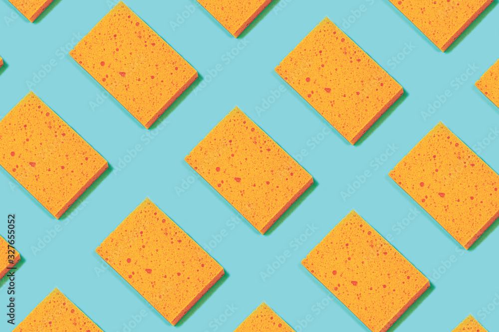 Trendy pattern collage made of orange color sponges on mint green blue background.