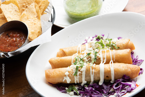 Mexican taquitos and tortilla chips with salsa photo