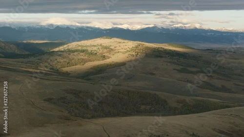 The early morning sunrise highlights the snow-covered summits of the Spanish Peaks in the Madison mountain Range near Bozeman, Montana photo