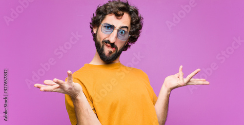 Tableau sur toile young crazy cool man looking puzzled, confused and stressed, wondering between d