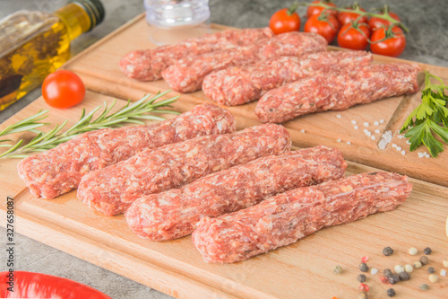 Raw beef sausages. Mititei - Romanian cuisine, on wooden boards with spices. Close-up
