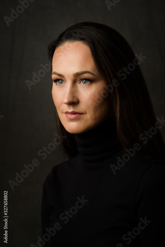 Dramatic portrait of a brunette woman on dark background