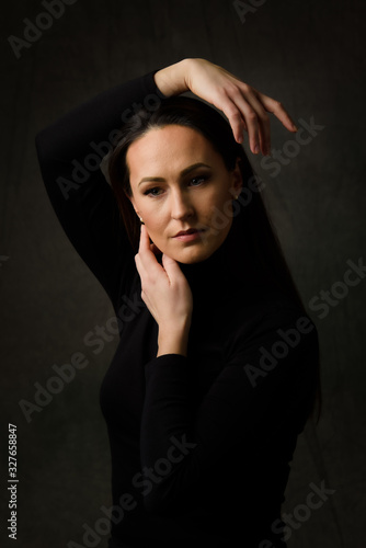 Dramatic portrait of a brunette woman on dark background