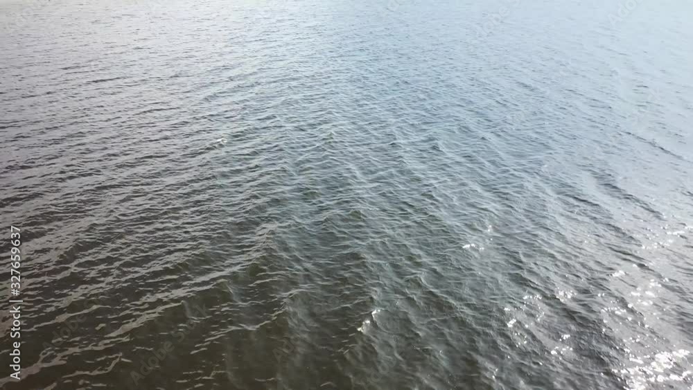 Low altitude flying over dark water surface with waves Low altitude flying over dark water surface with waves