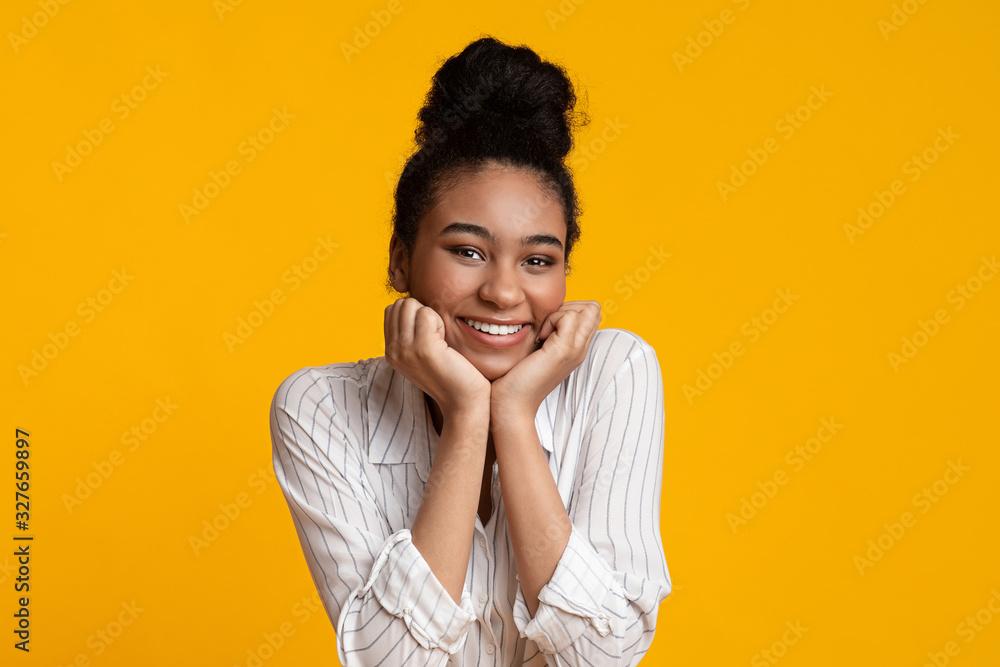 Joyful Black Girl Holding Hands On Cheeks And Smiling At Camera Joyful Black Girl Holding Hands On Cheeks And Smiling At Camera