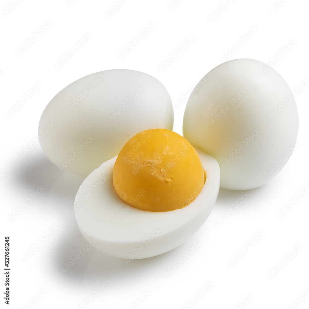 three boiled chicken eggs are lying nearby, one egg is cut in half, concept, close-up three boiled chicken eggs are lying nearby, one egg is cut in half, concept, close-up