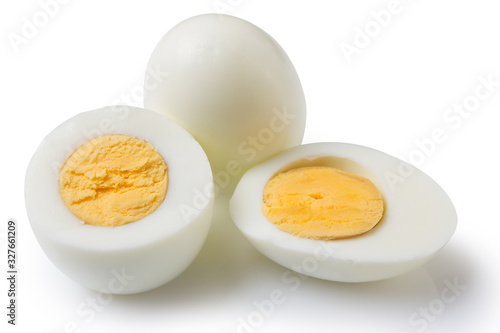 boiled peeled eggs on a white background, one whole egg two eggs are cut in half, the yolk is visible