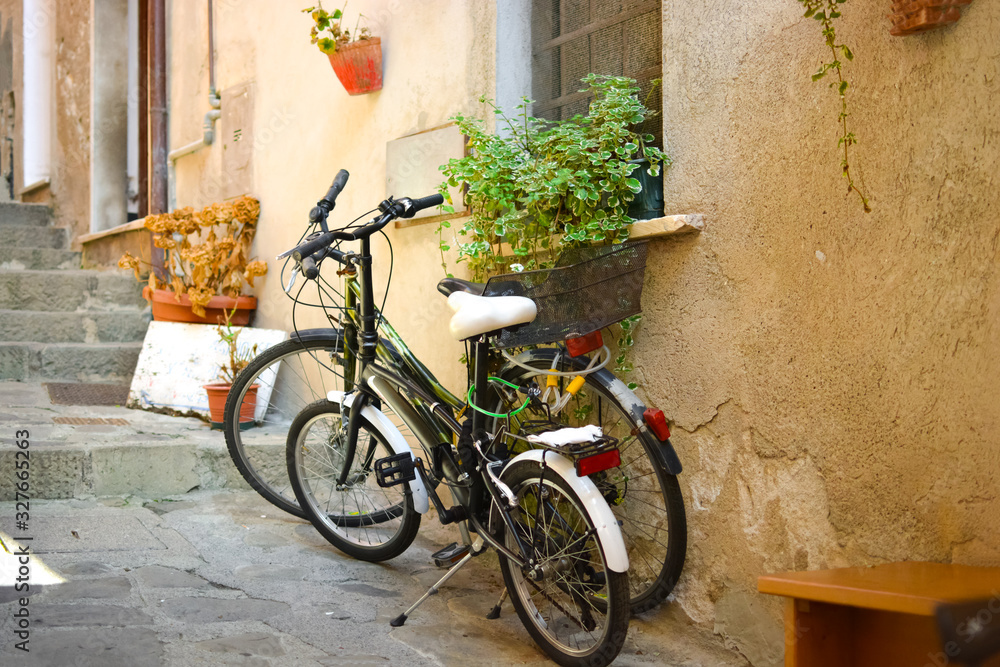 Two vintage bicycles are locked together in the old town of Monterosso al Mare, Italy, a picturesque town of the Cinque Terre.